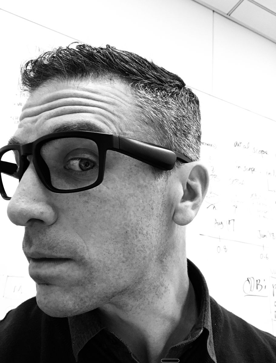 Todd wearing audio glasses in front of a whiteboard timeline