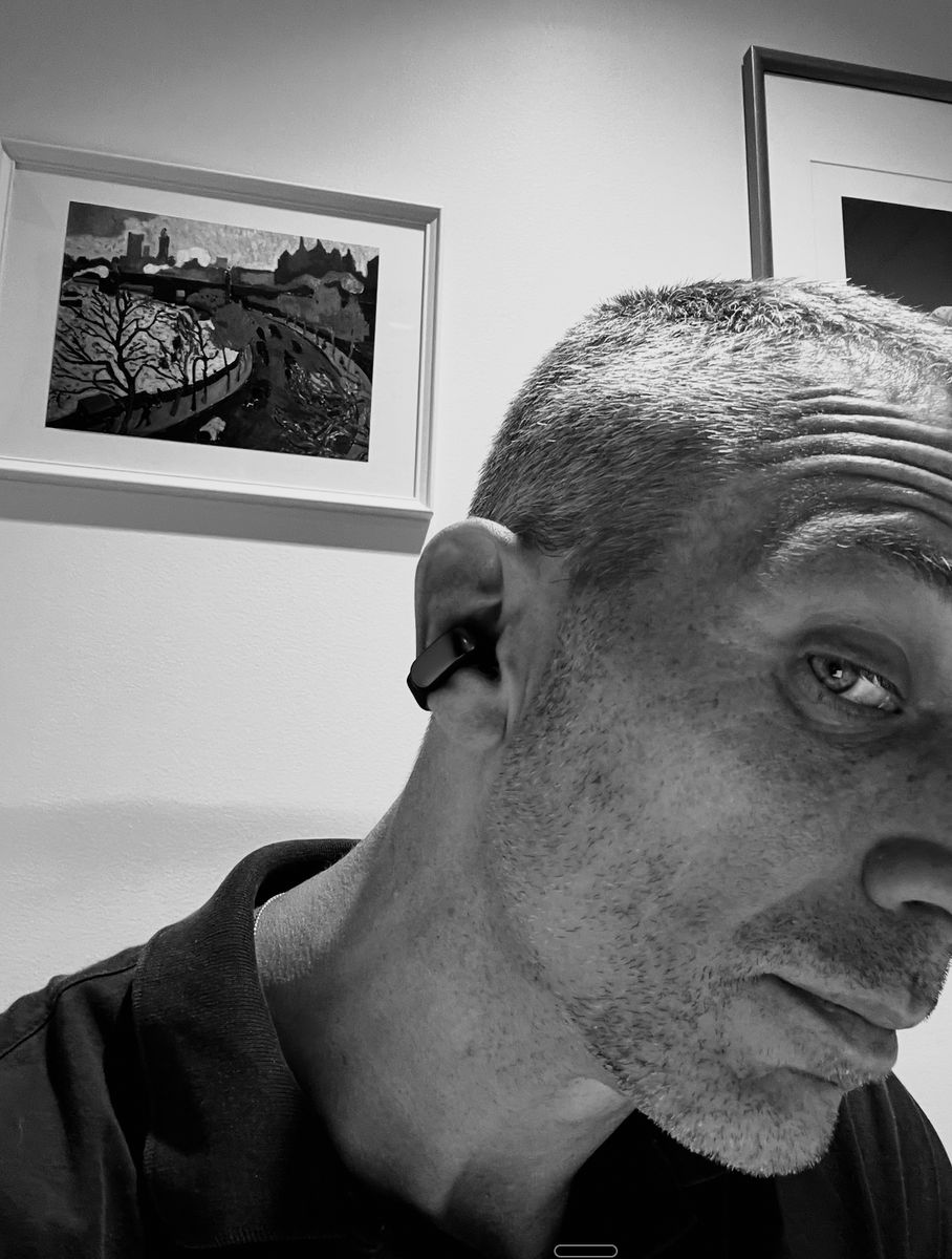 Todd wearing an open-ear earbud